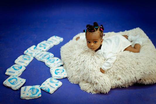 Bébé sur un tapis doux entouré de couches en forme de coeur