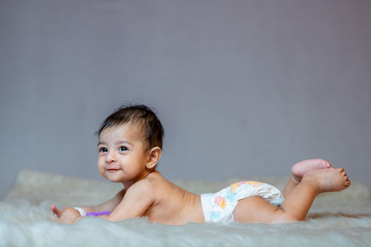Bébé souriant en couche sur couverture douce