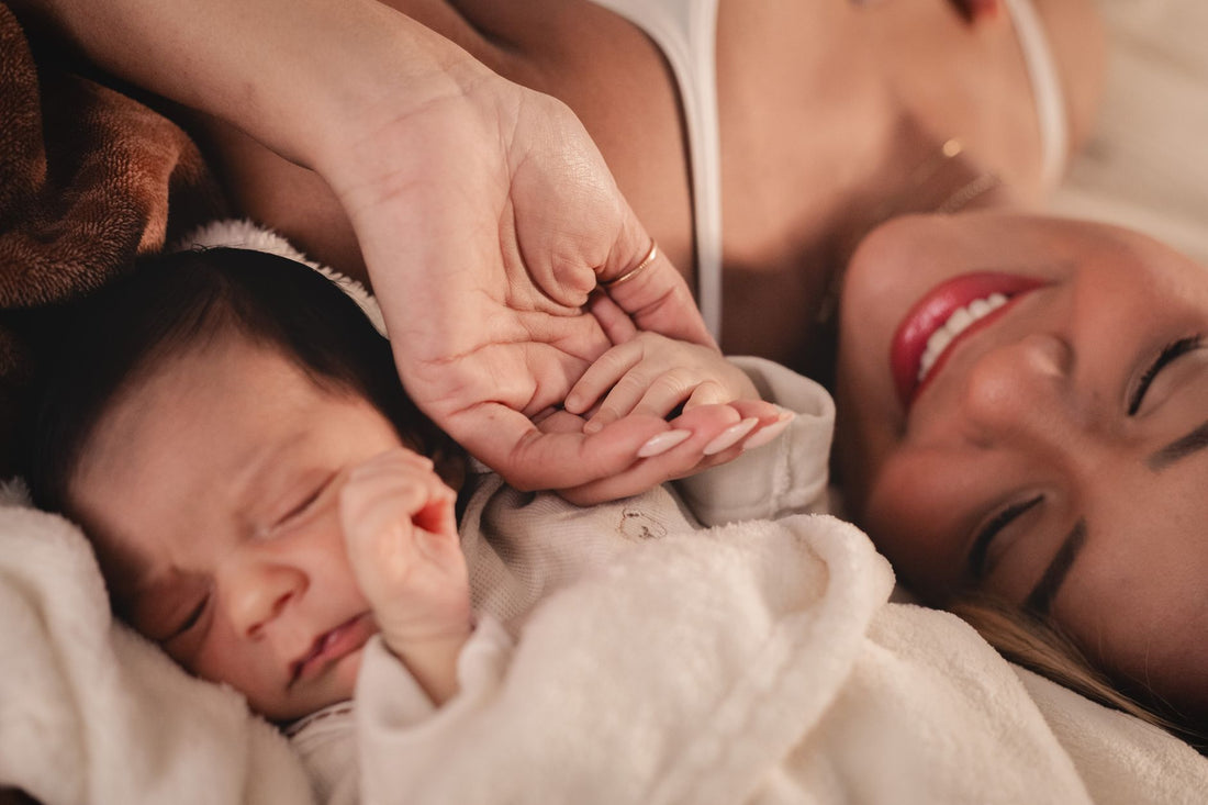 Bébé pendant son premier mois de vie tenant la main de sa maman