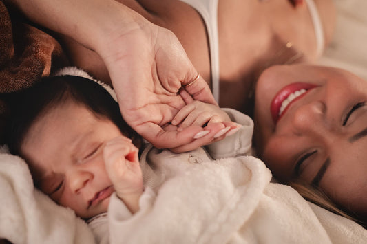 Bébé pendant son premier mois de vie tenant la main de sa maman