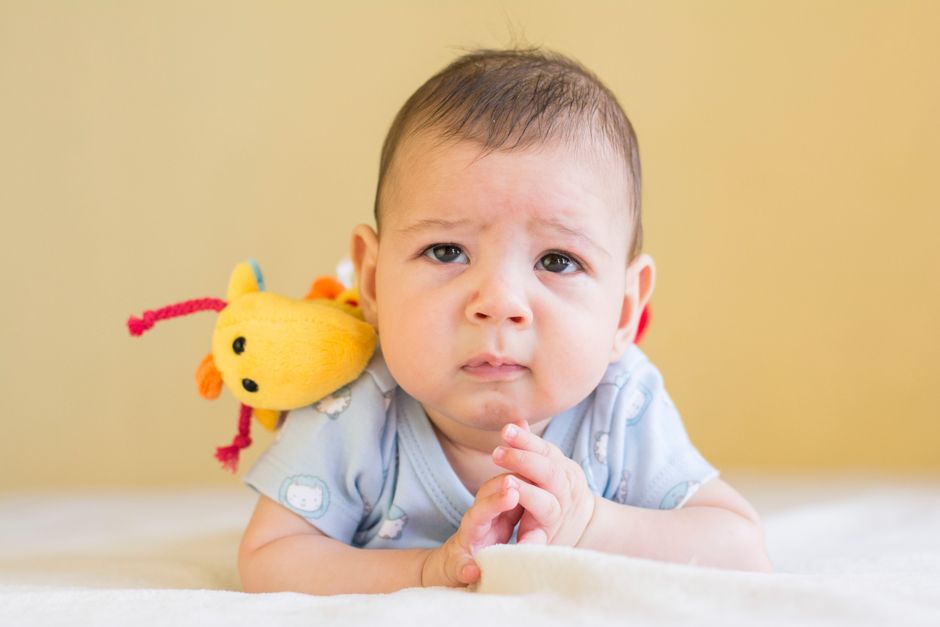 Bébé de 2 mois qui tient sa tête sur le ventre