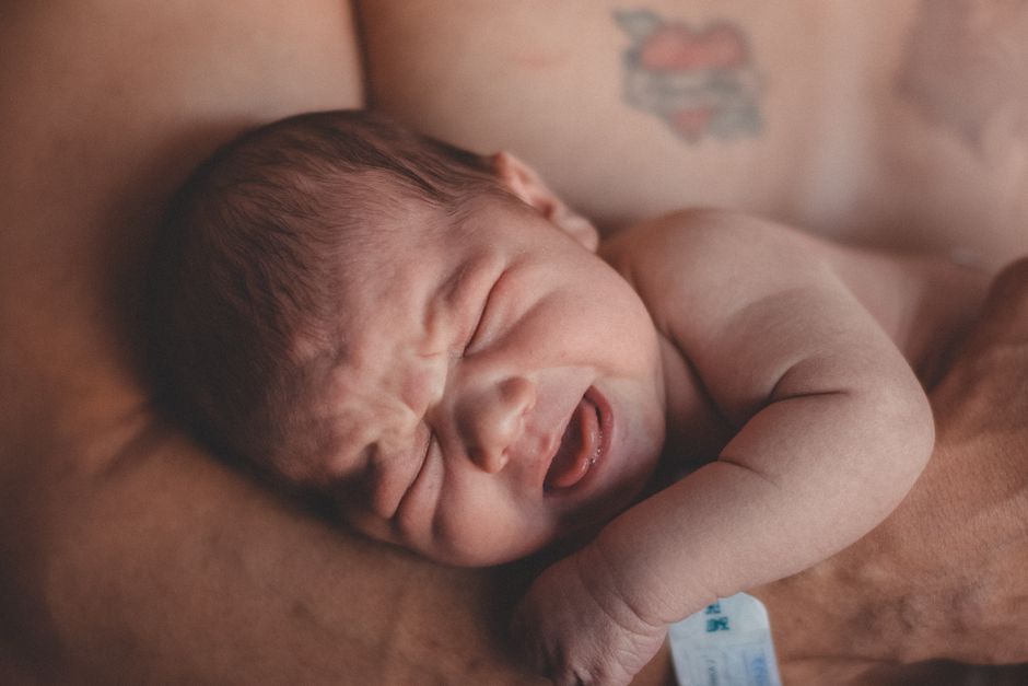Parent réconforte un nouveau-né qui pleure