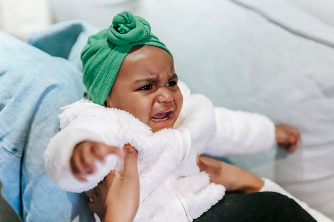 Bébé fatigué dans les bras de sa maman - régression du sommeil