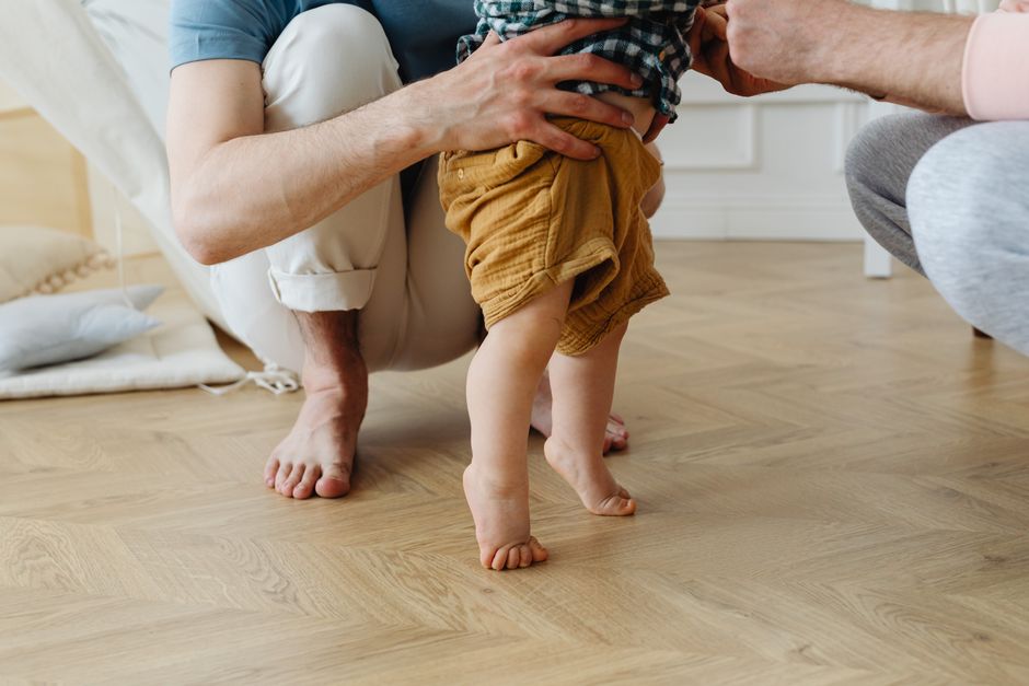 Bébé qui fait ses premiers pas debout main tenue