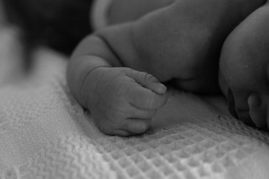 Petite main de nouveau-né endormi - taille réelle naissance